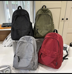 Detailed display of four plaid backpacks in black, green, grey, and red for school