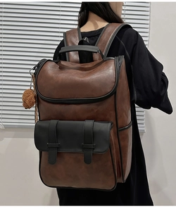 Detailed side view of brown PU leather backpack featuring contrast black flap and buckles