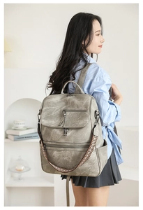Close-up of vintage grey backpack featuring textured leather and geometric woven strap