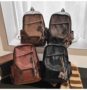 Detail of vintage faux leather backpacks in black and brown with cute dog charms