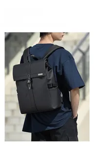 Close-up of black roll-top business backpack with buckle detail and wide shoulder straps