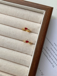 Vue détaillée de boucles d'oreilles vintage dorées avec gemme rouge et diamants blancs