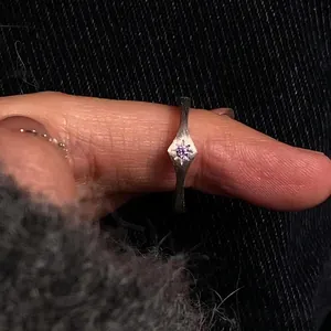 Matte silver starburst ring with purple gemstone and diamond-shaped brushed finish