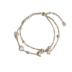 Bracelet double couche argenté avec papillon et perles sur fond blanc avec fermoir