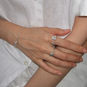 Ensemble élégant de bagues planétaires en argent avec zircon et bracelet sur lin blanc