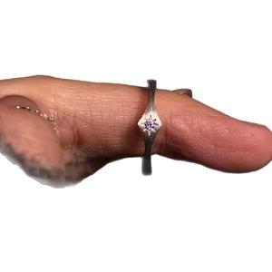 Elegant matte silver ring with a central purple gemstone and starburst engraving