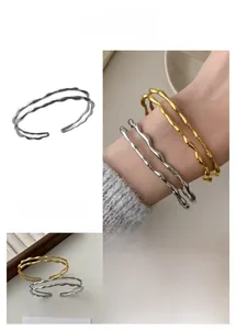Close-up of gold and silver irregular wave double-layer twisted bracelets for women