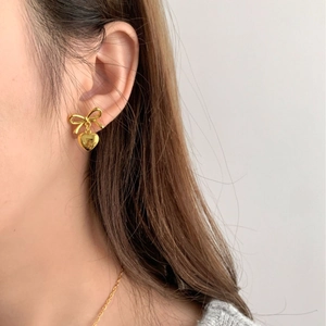 Elegant gold bow heart earrings shown on a model for a stylish Korean-inspired look