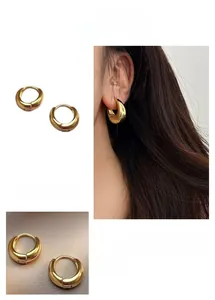Close-up of sleek gold teardrop hoop earrings with polished U-shaped minimalist design
