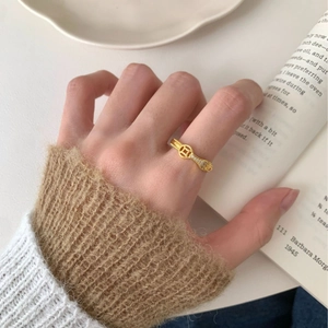 Bague vintage dorée avec motif pièce et zircons au doigt dans un décor de lecture