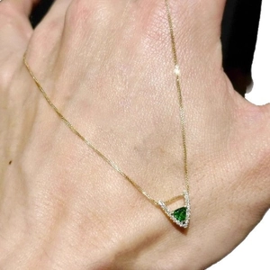 Elegant gold necklace with a triangular green zircon pendant and pavé crystal accents