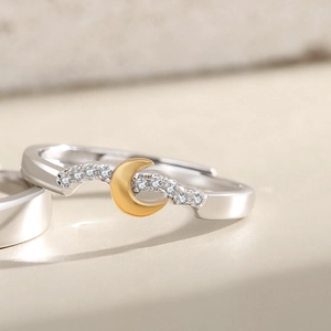 Detail of silver wavy ring featuring a golden crescent moon and zircon inlay accents