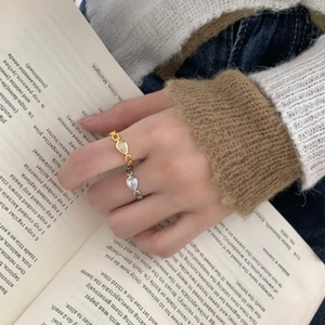 Exquisite gold and silver chain rings with pear-cut zircon on a hand in a chic setting