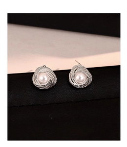 Close-up of vintage silver twist earrings featuring elegant round white pearls