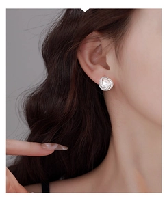 Close-up of French vintage silver triangle pearl earrings on model's ear
