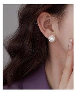 Detailed view of vintage silver twisted metal stud earrings with a white round pearl