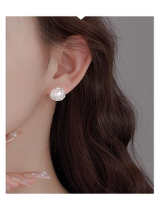 Close-up of elegant French vintage pearl stud earring with twisted silver spiral metal frame