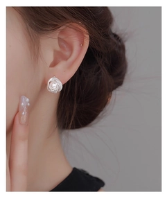 Close-up of a vintage pearl stud earring with silver twisted rope texture on a model