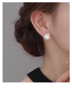 Close-up of French vintage knot pearl earrings with silver wire texture on model