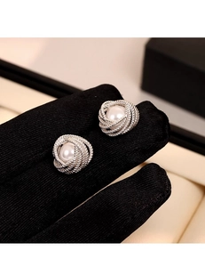 Close-up of French vintage silver spiral stud earrings with elegant white pearl inlay