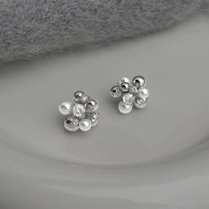 Elegant zircon pearl flower earrings in silver finish on a minimalist ceramic plate