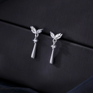 Silver leaf earrings with cubic zirconia teardrop tassels on black jewelry box lid