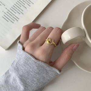 Elegant gold horse-shaped ring with zircon stones shown in a lifestyle setting