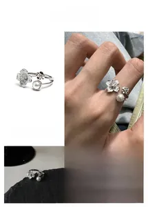 Close-up of brushed metal flower ring with pearl accent showing vintage texture
