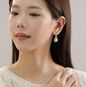 Elegant silver woven teardrop earrings with a white pearl and shimmering crystals