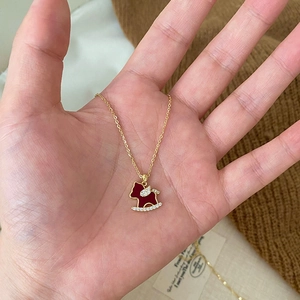Collier doré avec pendentif cheval à bascule rouge et pierres de zircone étincelantes