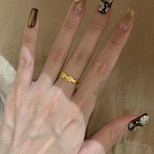 Elegante anello d'oro a onde con zirconi bianchi scintillanti su mano femminile