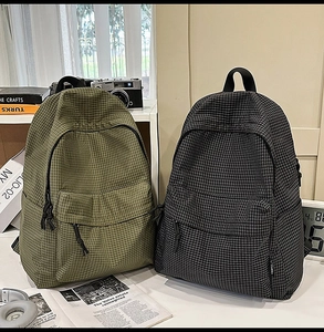 Classic checkered nylon backpacks in olive and black shown with travel and study accessories