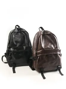Detail view of stylish PU leather backpacks in black and dark brown with smooth texture