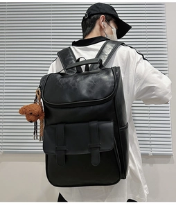 Side view of large black PU leather backpack with teddy charm on male model
