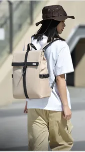 Outdoor shot of the minimalist beige travel backpack with buckle and roll-top design