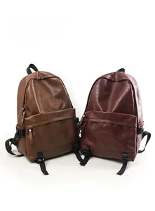 Detail view of vintage faux leather backpacks in caramel and burgundy with front pockets