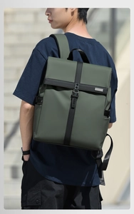 Outdoor view of waterproof roll-top business backpack in dark green with side pockets