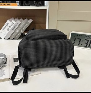 Detail of minimalist black and white checkered nylon backpack with adjustable straps