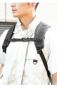 Detail of adjustable chest strap on black nylon backpack for pressure relief