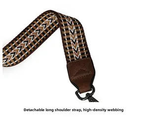 Detail of high-density woven strap with geometric patterns and brown leather ends