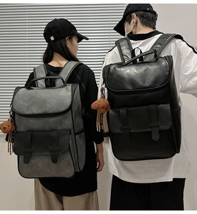 Detail of matte PU leather backpacks in black and grey with plush bear charm decorations