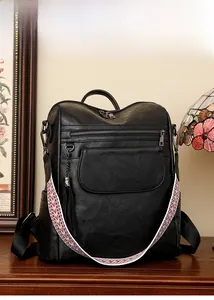 Détail d'un sac à dos vintage noir avec bandoulière tissée colorée et gland métallique
