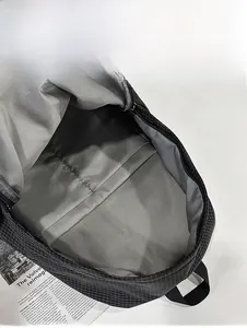 Interior view of checkered nylon backpack showing spacious main compartment and lining