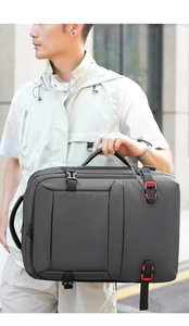 Detail of grey travel backpack showing dual handles and functional buckle closures