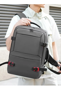 Detail of dark grey travel backpack with secure buckles and ergonomic straps on model