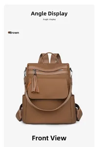 Close-up of brown fringe tassel zipper pocket on textured woven fashion backpack