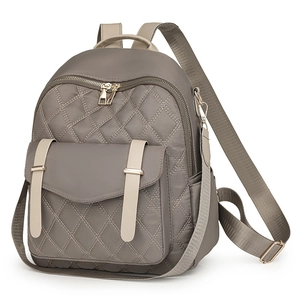 Détail du sac à dos matelassé taupe avec coutures en losange et poche à boucle sur fond blanc