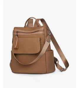 Side view of khaki fringe backpack with textured fabric and vintage soft leather details