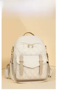 Détail du sac à dos beige matelassé avec matériau imperméable et zips dorés