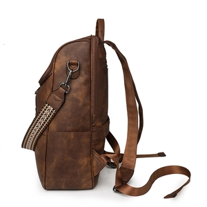 Vintage brown leather backpack with colorful woven strap and side pocket view
